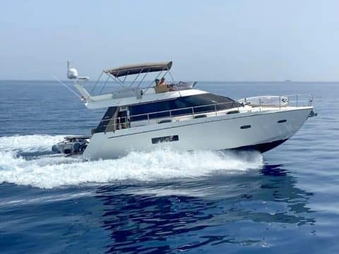 Sealine F42 Achates motor yacht at sea with captain on fly bridge available for charter in Singapore